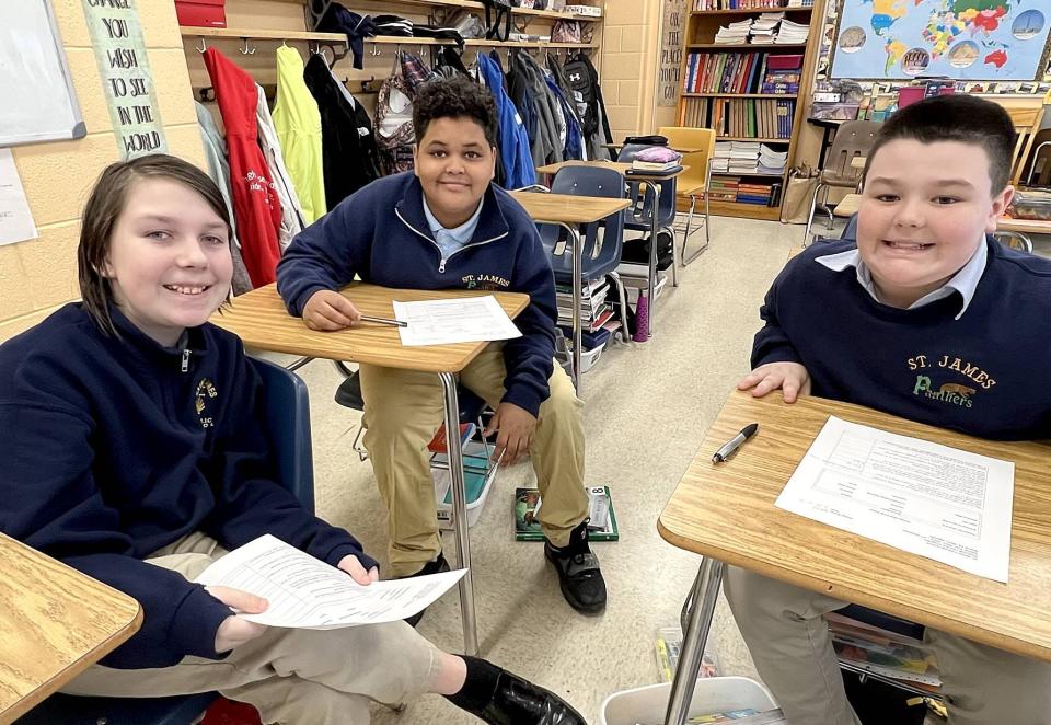 St. James School students, from left, Nicholas Pepperman, Benjamin Torres-Quinones and Lawson Roward work on a group exercise during their financial literacy elective on March 24.