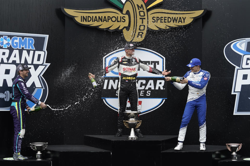 Rinus VeeKay, center, of the Netherlands, celebrates with Romain Grosjean, left, of Switzerland, and Alex Palou, of Spain, after VeeKay won an IndyCar auto race at Indianapolis Motor Speedway, Saturday, May 15, 2021, in Indianapolis. (AP Photo/Darron Cummings)