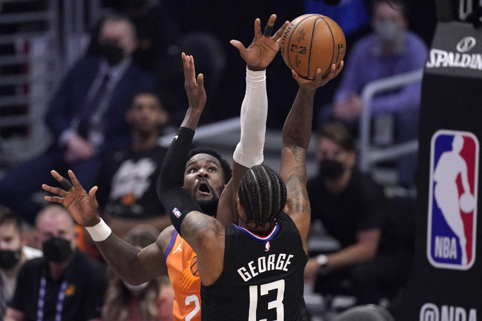 Los Angeles Clippers guard Paul George, right, shoots as Phoenix Suns center Deandre Ayton defends during the first half in Game 6 of the NBA basketball Western Conference Finals Wednesday, June 30, 2021, in Los Angeles. (AP Photo/Mark J. Terrill)