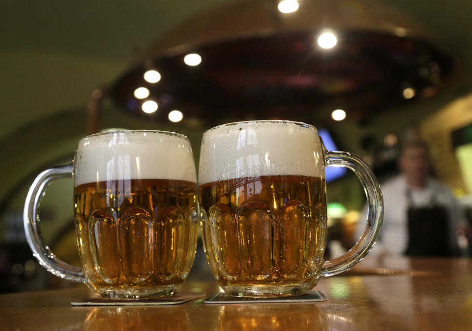 FILE - Glasses of beer lie on a table in a pub in Prague, Czech Republic, on Feb. 2, 2016. The Czech citizens will likely pay more for beer and medicine while businesses will face higher corporate taxes as part of a package of dozens of measures designed to keep the ballooning budget deficit under control, the government said on Thursday May, 11, 2023, Prime Minister Petr Fiala said the measures are necessary because the pace of the debt rise is "threatening." (AP Photo/Petr David Josek/File)