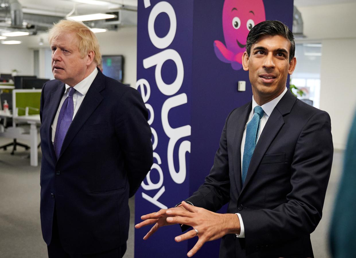 Britain's Prime Minister Boris Johnson (L) and Britain's Chancellor of the Exchequer Rishi Sunak react as they talk with members of staff during their visit to the headquarters of energy supplier Octopus Energy in London on October 05, 2020. - The visit coincides with the company's plan to create 1,000 new technology jobs across sites in England. (Photo by Leon Neal / POOL / AFP) (Photo by LEON NEAL/POOL/AFP via Getty Images)