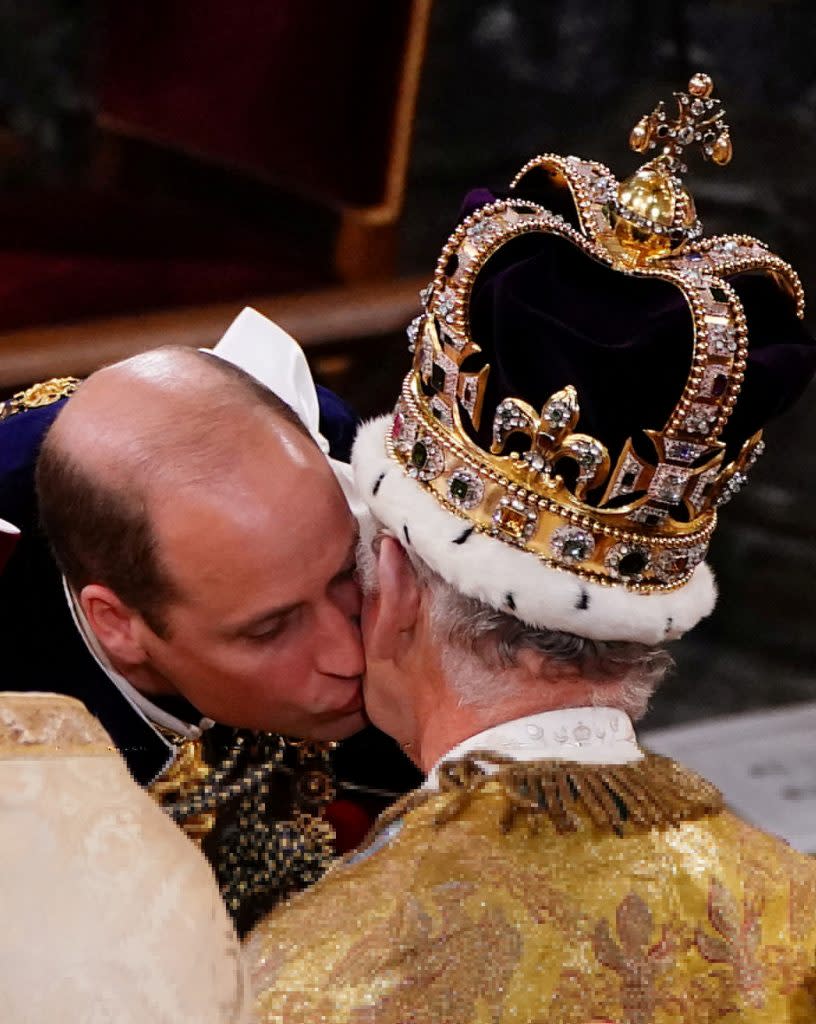 威廉王子在父親面前屈膝下跪親吻臉頰，宣誓對君主效忠。（路透）