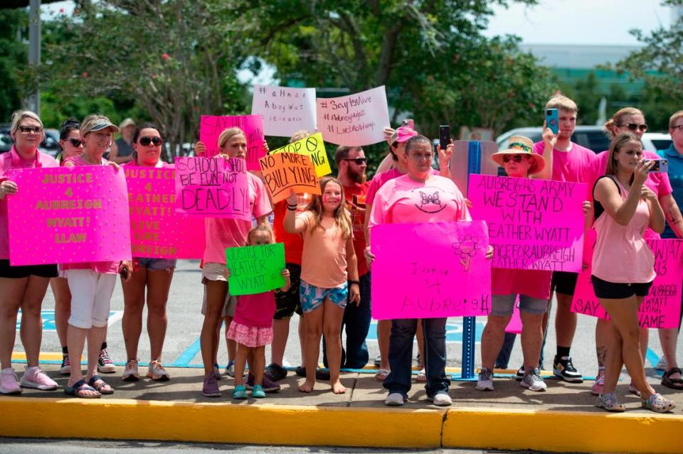 Protestors in support of Heather Wyatt and Aubreigh Wyatt hold signs, take photos and livestream on various social media platforms outside the Jackson County Courts building on Thursday, July 18, 2024, as Heather Wyatt participates in a chancery court hearing inside the courthouse.