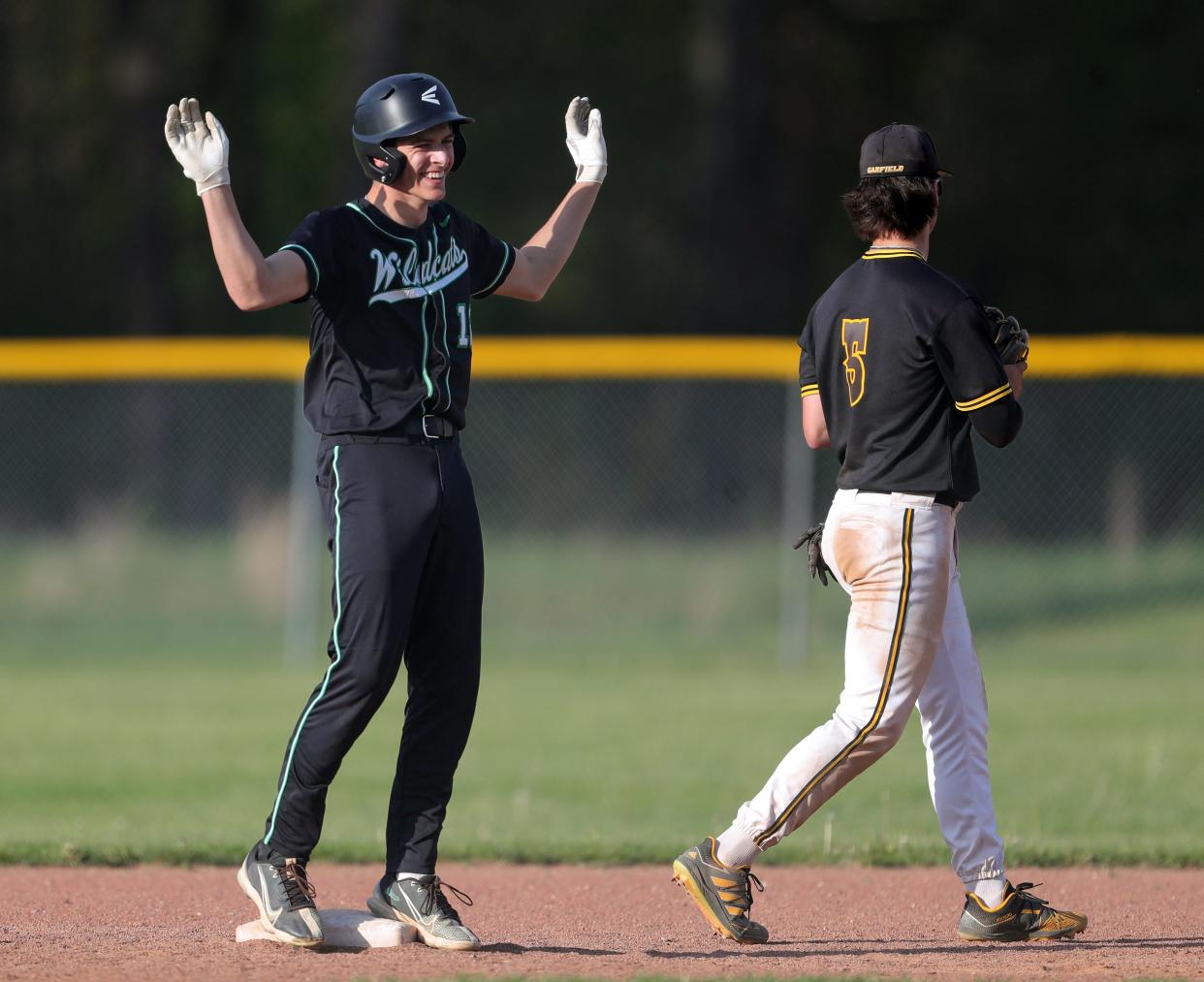 Mogadore designated hitter Cole Reese, left, celebrates at second next to Garfield shortstop Eric Geddes after hitting an RBI double to right field during the fifth inning of a high school baseball game, Wednesday, May 1, 2024, in Garrettsville, Ohio.