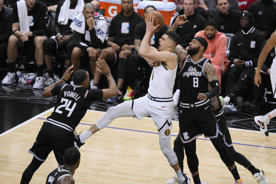 Denver Nuggets forward Michael Porter Jr., center, drives to the basket past Los Angeles Clippers forward Norman Powell (24) and forward Marcus Morris Sr. (8) during the second half of an NBA basketball game Friday, Jan. 13, 2023, in Los Angeles. (AP Photo/Marcio Jose Sanchez)