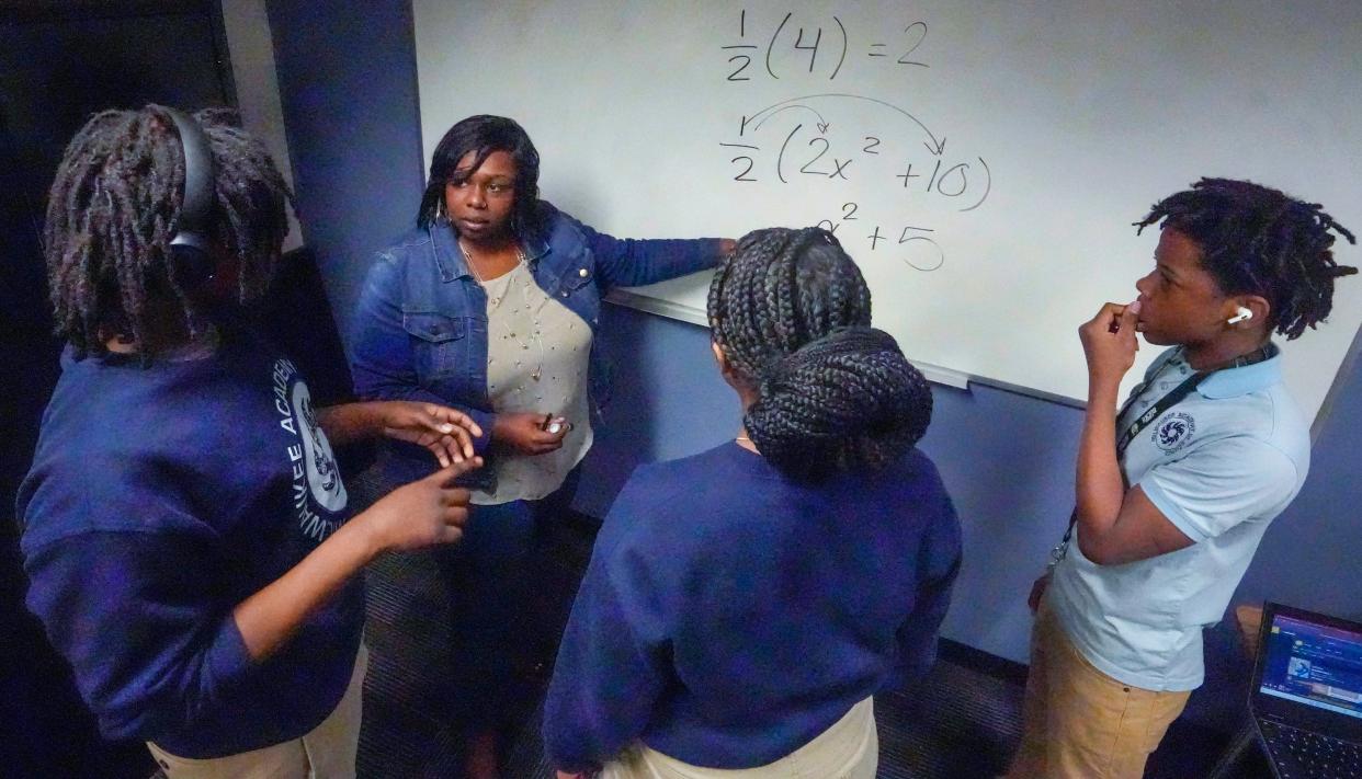 Markita Hutchinson in the Teach for America program breaks down math problem for Milwaukee Academy of Science students in May 2023.