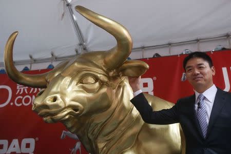 Richard Liu, CEO and founder of China's e-commerce company JD.com, poses next to a Wall Street bull after ringing the opening bell at the NASDAQ Market Site building at Times Square in New York May 22, 2014. REUTERS/Shannon Stapleton