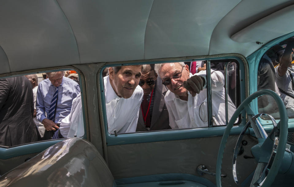 FILE - In this Aug. 14, 2015 file photo, Havana City Historian Eusebio Leal Spengler, right, points out something to U.S. Secretary of State John Kerry as they peer into the interior of a classic American car parked in Old Havana, Cuba, during Kerry's trip to reopen the U.S. Embassy. Leal, who oversaw the transformation of crumbling Old Havana to an immaculately restored colonial tourist attraction, becoming the de-facto mayor of the historic city center and one of the nation’s most prominent public intellectuals, has died according to state media on Friday, July 31, 2020, after a long battle with cancer. (AP Photo/Ramon Espinosa, File)
