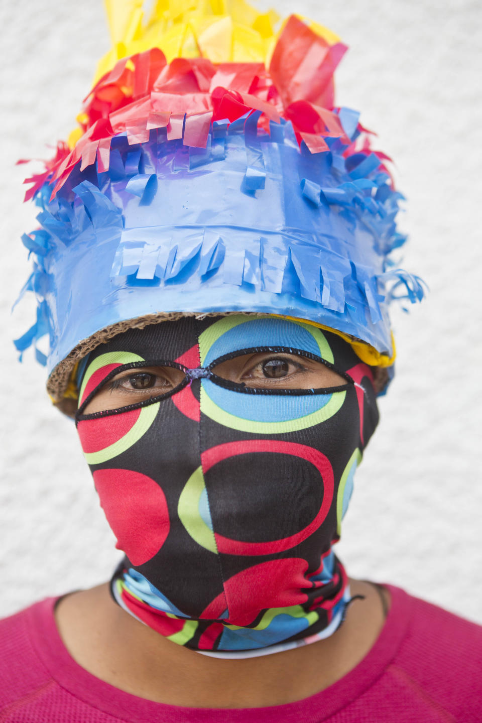 In this April 18, 2014 photo, a youth wearing his hand made mask poses for a picture as he takes a break from the "Los Encadenados," or The Chained Ones procession on Good Friday during Holy Week in Masatepe, Nicaragua. The youth played the part of the crowd who used chains to carry away Jesus and Judas. Dressing up in colorful masks and costumes, and dragging chained “Judases” through the streets, residents participate by attaching long chains to people portraying Judas and drag them around, sometimes symbolically kicking and beating them, in punishment for betraying Jesus Christ(AP Photo/Esteban Felix)