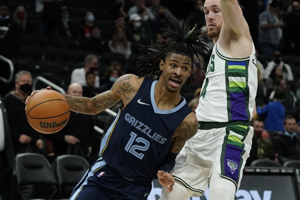 Memphis Grizzlies' Ja Morant trives past Milwaukee Bucks' Pat Connaughton during the second half of an NBA basketball game Wednesday, Jan. 19, 2022, in Milwaukee. (AP Photo/Morry Gash)