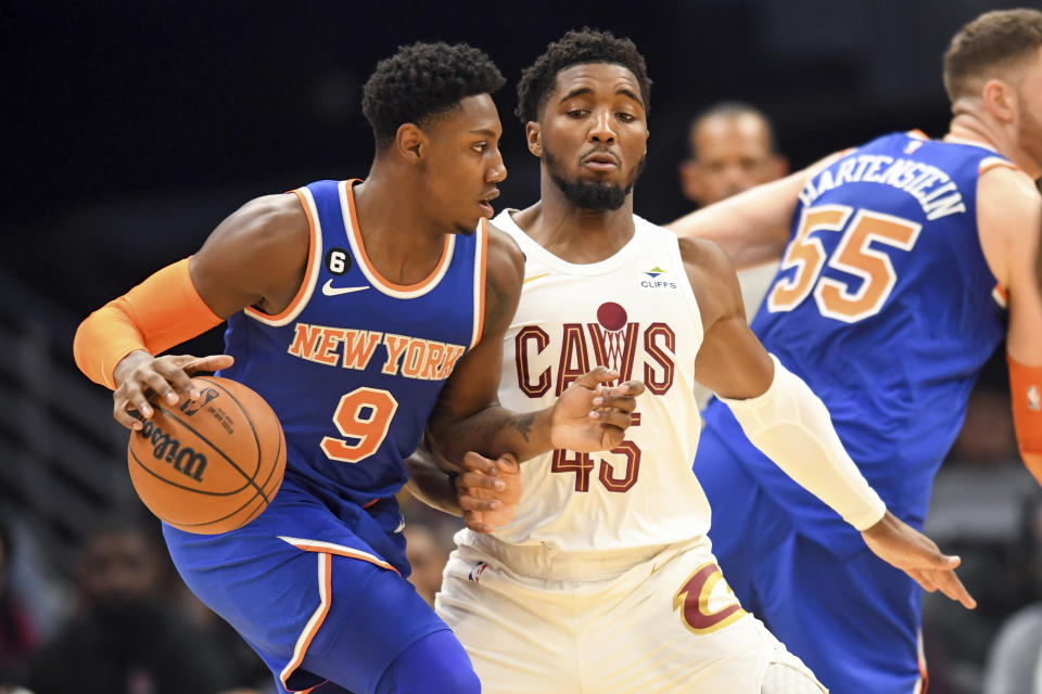 New York Knicks guard RJ Barrett (9) drives against Cleveland Cavaliers guard Donovan Mitchell (45) during the first half of an NBA basketball game, Sunday, Oct. 30, 2022, in Cleveland. (AP Photo/Nick Cammett)