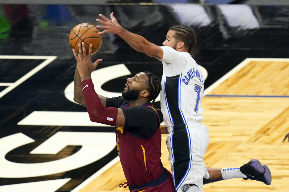 Orlando Magic guard Michael Carter-Williams (7) blocks a shot by Cleveland Cavaliers center Andre Drummond, left, during the second half of an NBA basketball game, Monday, Jan. 4, 2021, in Orlando, Fla. (AP Photo/John Raoux)