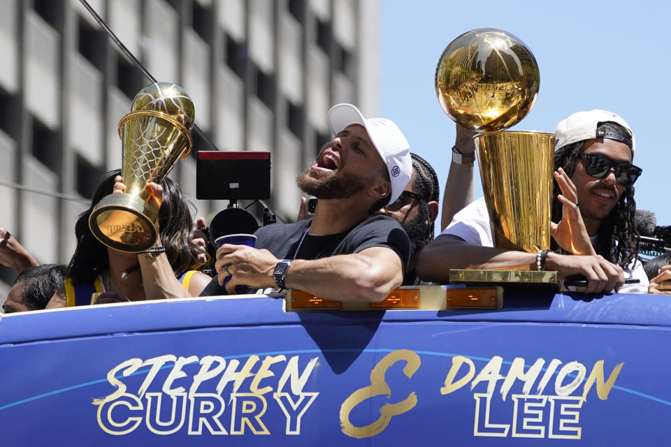 Stephen Curry and Damion Lee, right, ride in the Golden State Warriors NBA championship parade in San Francisco, Monday, June 20, 2022. (AP Photo/Eric Risberg)