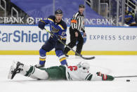 St. Louis Blues' Jaden Schwartz (17) slides the puck past a diving Minnesota Wild's Jared Spurgeon in the second period of an NHL hockey game, Wednesday, May 12, 2021 in St. Louis. (AP Photo/Tom Gannam)