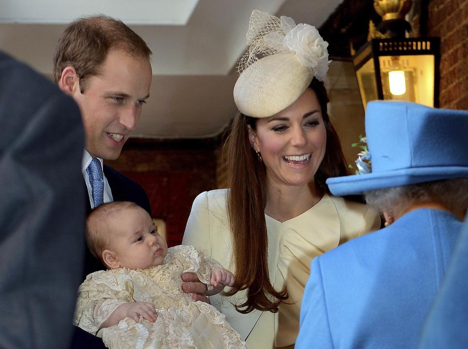 Britain's Prince William carries his son Prince George, as he arrives with his wife Catherine, Duchess of Cambridge for their son's christening at St James's Palace in London