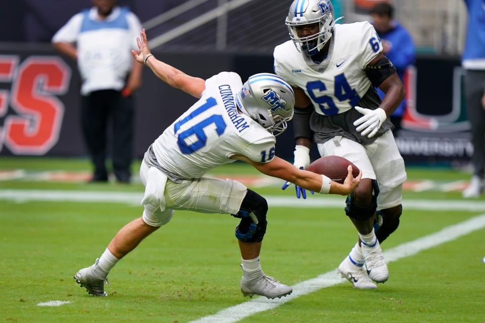 Middle Tennessee quarterback Chase Cunningham (16) runs the ball in for a touch down as offensive lineman Jacqui Graham (64) looks on during the first half of an NCAA college football game against Miami, Saturday, Sept. 24, 2022, in Miami Gardens, Fla. (AP Photo/Wilfredo Lee)