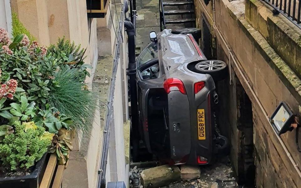 Car stuck in alley outside Bath Hotel - @TouristHeaven/Twitter