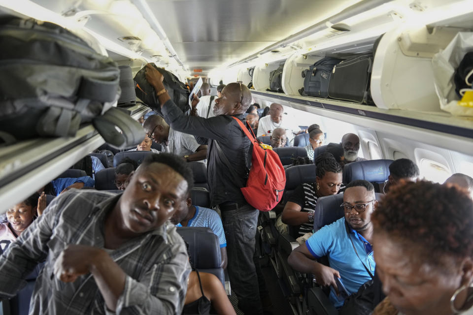 Passengers board a World Atlantic plane before take-off at the Toussaint Louverture International Airport in Port-au-Prince, Haiti, Monday, May 20, 2024. Haiti's main international airport reopened Monday for the first time after gang violence forced authorities to close it in early March. (AP Photo/Ramon Espinosa)