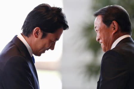 Japan's new Environment Minister Shinjiro Koizumi reacts next to Deputy Prime Minister and Finance Minister Taro Aso, as he arrives at Prime Minister Shinzo Abe's official residence in Tokyo