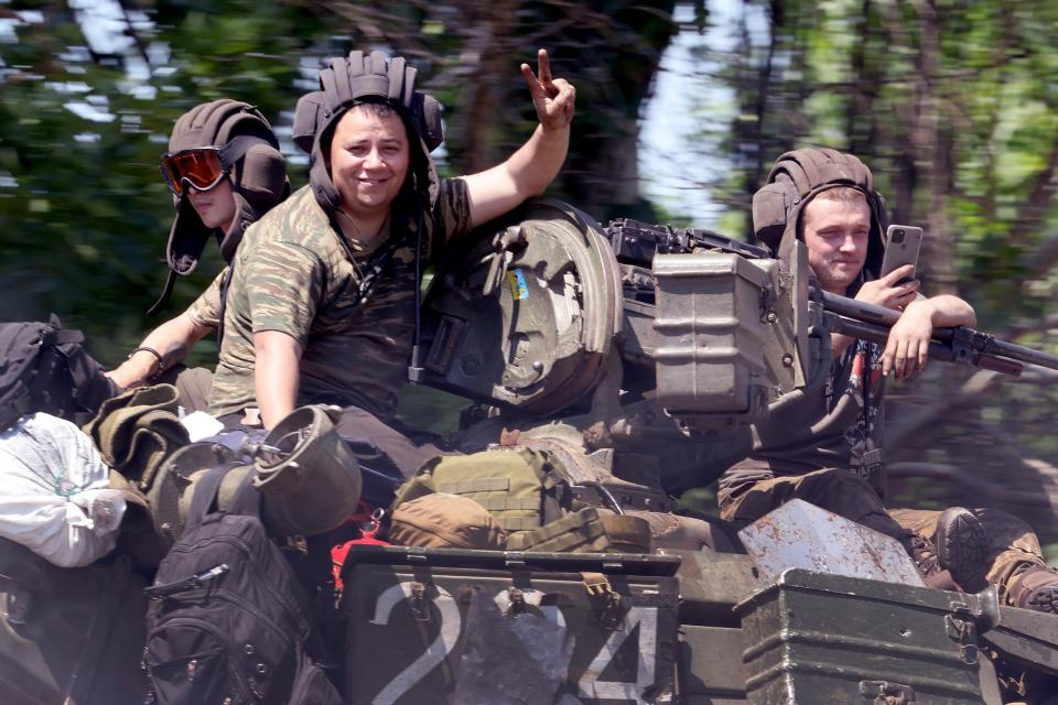Soldiers ride on a tank as it is hauled down the highway near Bakhmut, Ukraine (Getty Images)