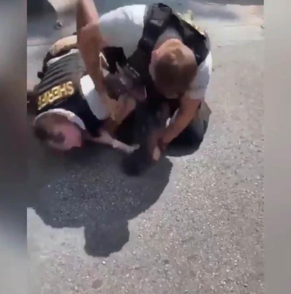 A screenshot from a video making the rounds online depicting a Georgia law enforcement officer striking a Black man in the head as two attempt to arrest him. (Via Twitter)