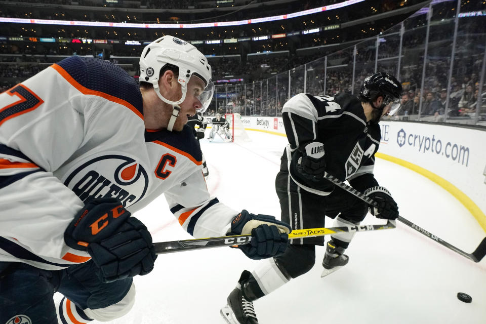 Edmonton Oilers center Connor McDavid, left, and Los Angeles Kings center Phillip Danault goes after the puck during the third period of an NHL hockey game Thursday, April 7, 2022, in Los Angeles. (AP Photo/Mark J. Terrill)