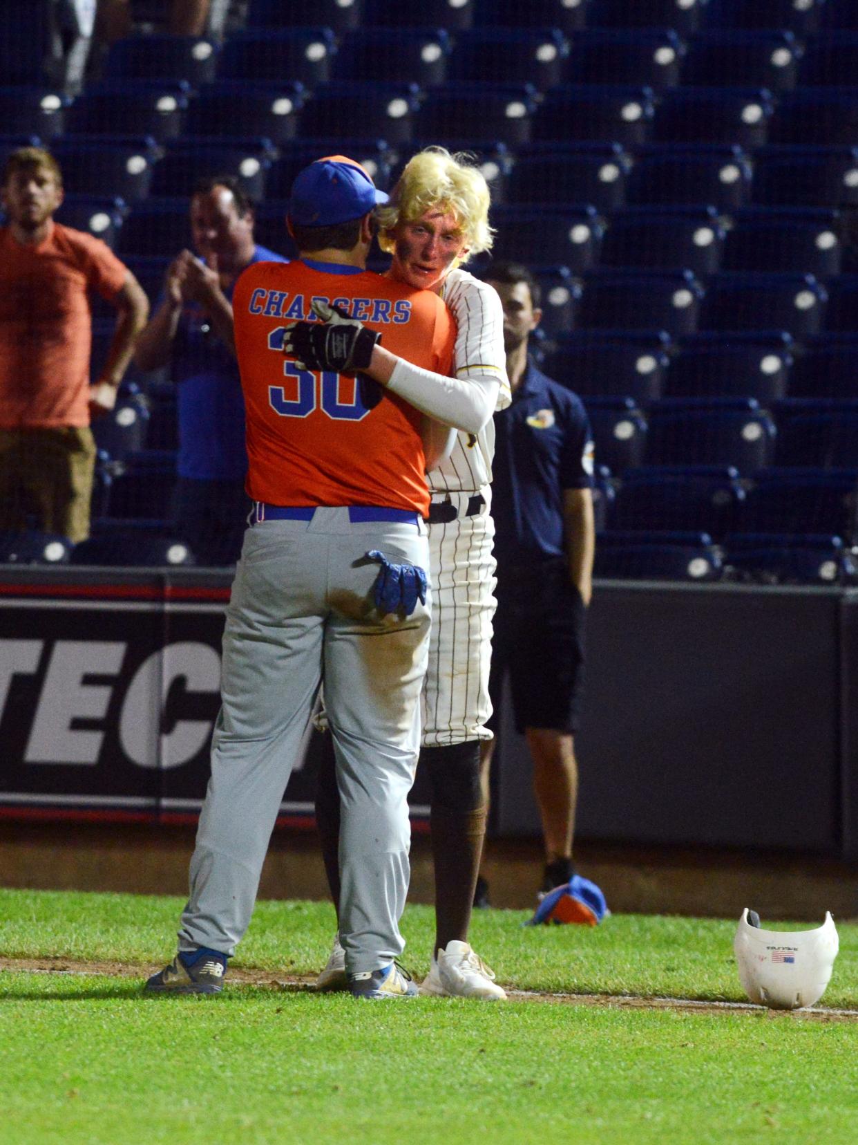 Ty Brenner gets a hug from Noah Smith after Roger Bacon's 3-0 loss in eight innings to Milan Edison in a Division III state semifinal at Akron's Canal Park.