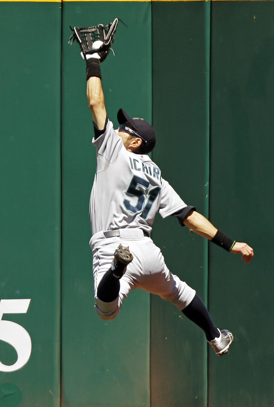 FILE - Seattle Mariners right fielder Ichiro Suzuki, of Japan makes a leaping catch at the wall to rob Cleveland Indians' Carlos Santana of a hit in the fourth inning of a baseball game Thursday, May 17, 2012, in Cleveland. About a dozen Japanese players will play in MLB this season, adding to a list has reached about 70 since Masanori Murakami in 1964-65. (AP Photo/Mark Duncan, FIle)