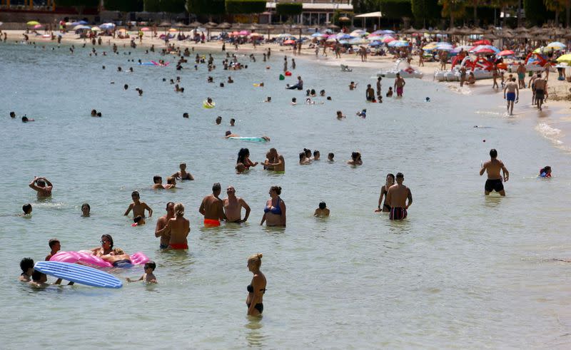 FILE PHOTO: People sunbathe at Magaluf beach in Mallorca