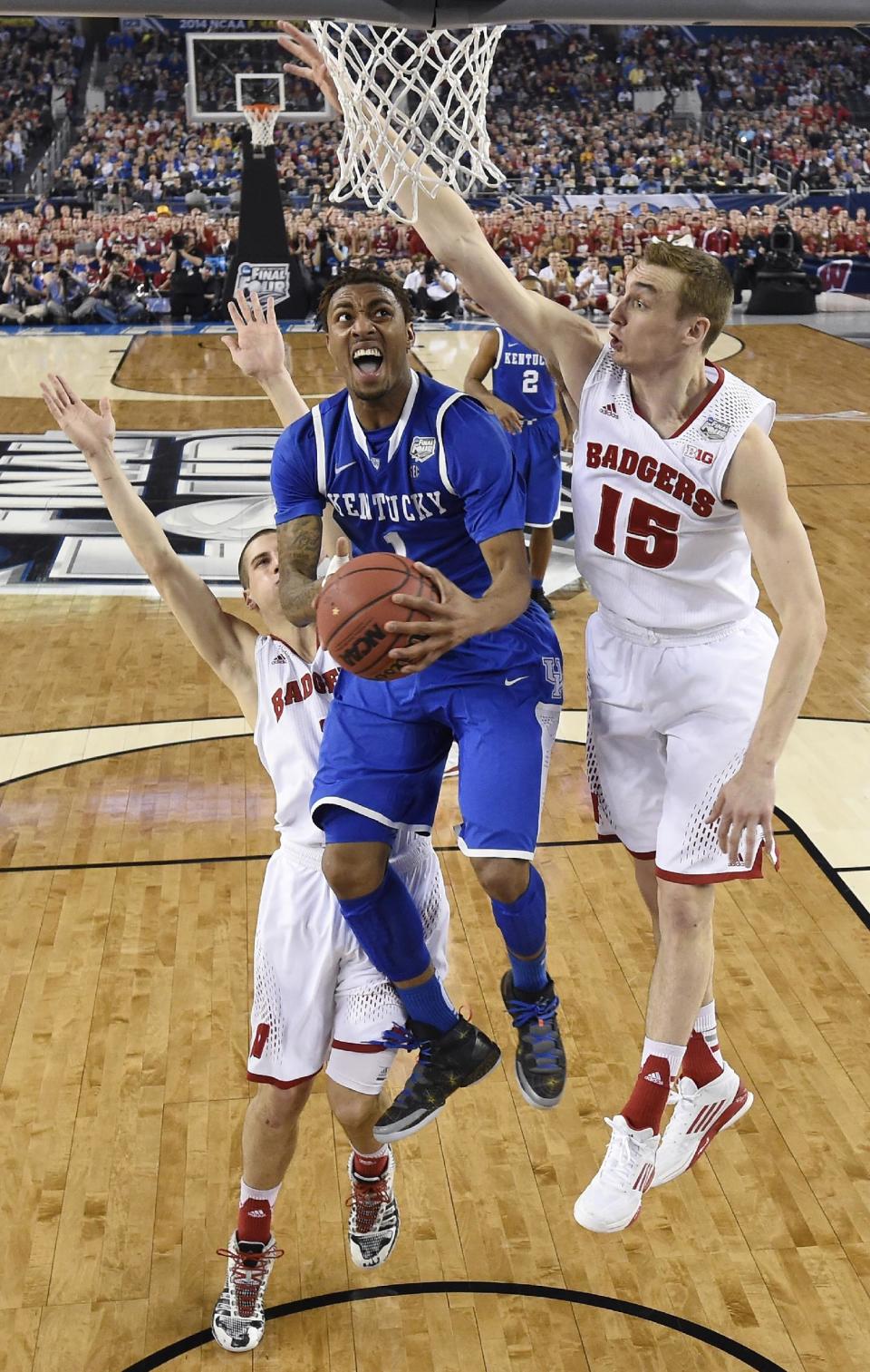 Kentucky guard James Young, center, drives to the basket between Wisconsin's Ben Brust, left, and Sam Dekker during the second half of an NCAA Final Four tournament college basketball semifinal game Saturday, April 5, 2014, in Arlington, Texas. (AP Photo/Chris Steppig, pool)
