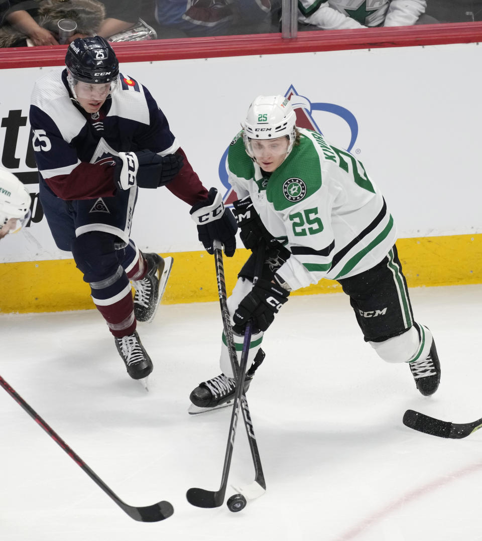 Dallas Stars left wing Joel Kiviranta, right, collects the puck as Colorado Avalanche right wing Logan O'Connor defends in the third period of an NHL hockey game Saturday, April 1, 2023, in Denver. (AP Photo/David Zalubowski)