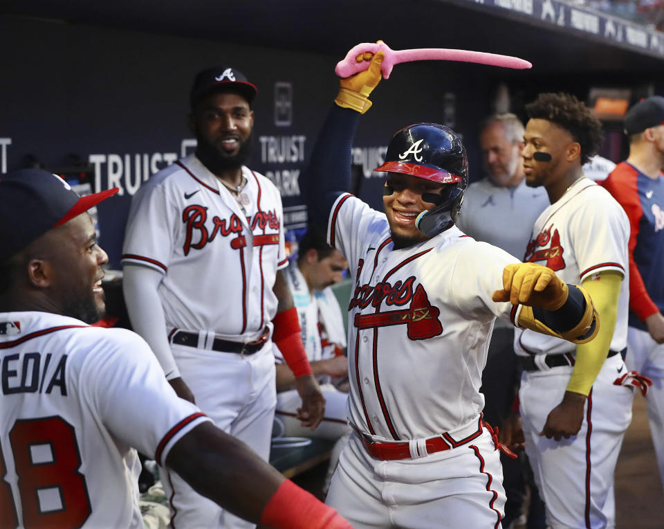Atlanta Braves' William Contreras swings the pink sword in the dugout after his home run against the New York Mets during the second inning of a baseball game Monday, Aug. 15, 2022, in Atlanta. (Curtis Compton/Atlanta Journal-Constitution via AP)