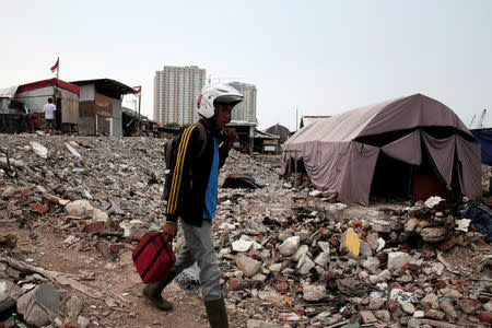 A man walks near a temporary shelter for people whose homes were demolished during eviction by the city authorities at Luar Batang district in Jakarta, Indonesia, November 11, 2016. REUTERS/Beawiharta