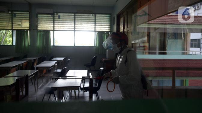 Petugas Palang Merah Indonesia (PMI) menyemprotkan cairan disinfektan di SMA 70 Jakarta, Kamis (27/1/2022). Pemprov DKI Jakarta mencatat ada 90 sekolah ditutup sementara akibat ditemukannya kasus COVID-19 varian Omicron yang tersebar di lima kota administrasi DKI Jakarta. (merdeka.com/Imam Buhori)