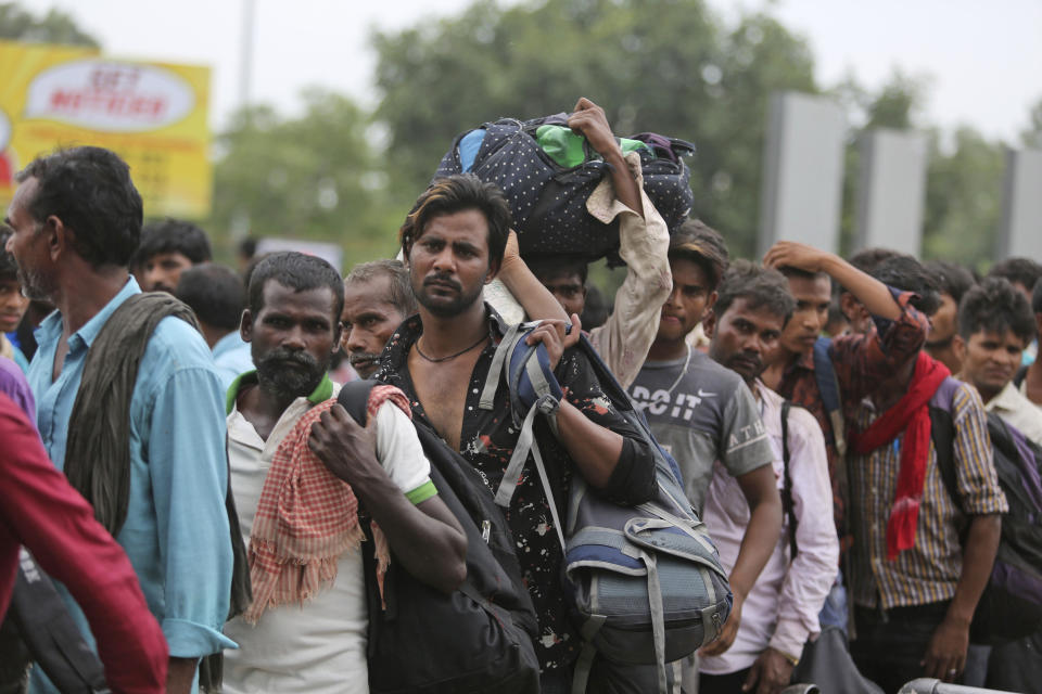 Indian migrant laborers carry their luggage and prepare to leave the region, at a railway station in Jammu, India, Wednesday, Aug. 7, 2019. Indian lawmakers passed a bill Tuesday that strips statehood from the Indian-administered portion of Muslim-majority Kashmir, which remains under an indefinite security lockdown, actions that archrival Pakistan warned could lead to war. (AP Photo/Channi Anand)