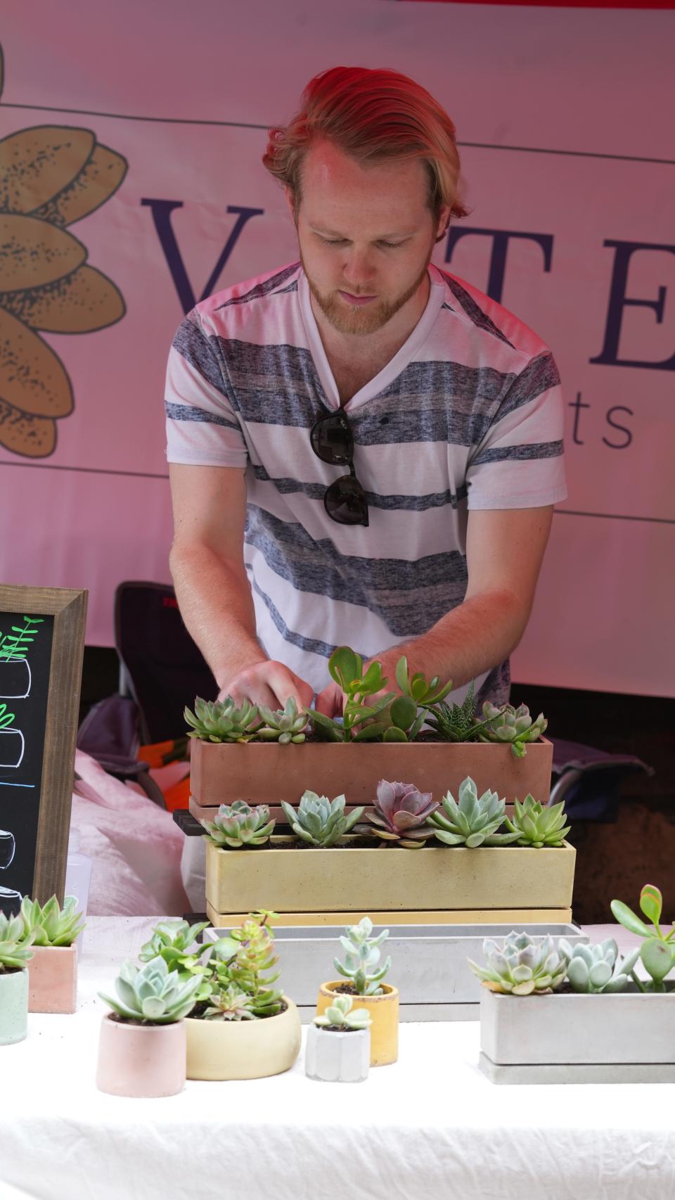 Nick Rehm adjusts the plants at Vate Succulents at the Pearl Market Downtown. Rehm and co-owner Mike Styer are in their second season selling at farmers markets. Rehm said he spent all winter perfecting the manufacturing of the concrete planters they sell.
