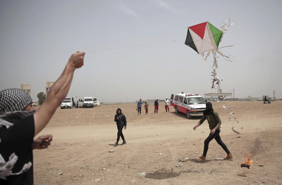 FILE - In this April 20, 2018 file photo, Palestinian protesters fly a kite with a burning rag dangling from its tail during a protest at the Gaza Strip's border with Israel.Hamas officials say Egypt is trying to broker a broad new cease-fire deal between Gaza’s ruling group and Israel to pave the way for Gaza's reconstruction and an eventual prisoner swap. Repeated cease-fire deals over the years collapsed, but there were signs Thursday, Aug. 2, 2018, of possible momentum toward a new agreement, after weeks of escalation between Israel and Hamas. (AP Photo/Khalil Hamra, File)