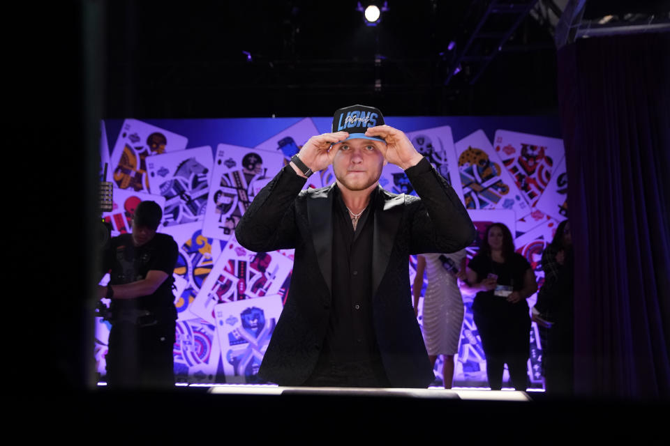 Michigan defensive end Aidan Hutchinson puts on a hat after being selected by the Detroit Lions as the second pick in the NFL football draft Thursday, April 28, 2022, in Las Vegas. (AP Photo/John Locher )