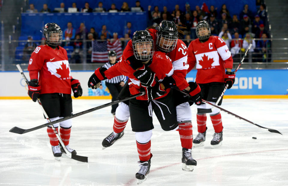 SOCHI, RUSSIA - FEBRUARY 12:  Meghan Agosta-Marciano #2 of Canada celebrates after scoring a goal with Natalie Spooner #24 in the third period against the United States during the Women's Ice Hockey Preliminary Round Group A game on day five of the Sochi 2014 Winter Olympics at Shayba Arena on February 12, 2014 in Sochi, Russia.  (Photo by Paul Gilham/Getty Images) 