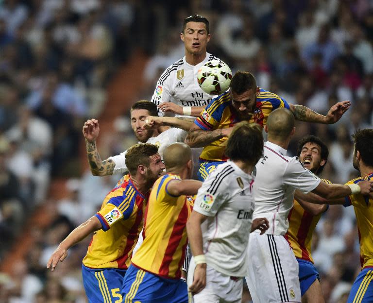 Real Madrid's Portuguese forward Cristiano Ronaldo (Top) vies with Valencia's midfielder Javi Fuego (TopR) during the Spanish league football match in Madrid on May 9, 2015