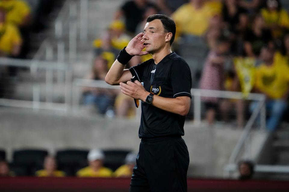 Referee Sergii Boiko listens to his earpiece during a Crew game at Lower.com Field.