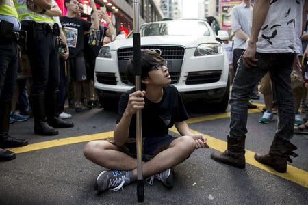 A localist protester sits in the middle of the road during an anti-China protest at Mongkok shopping district in Hong Kong, China July 11, 2015. Picture taken July 11, 2015. REUTERS/Tyrone Siu