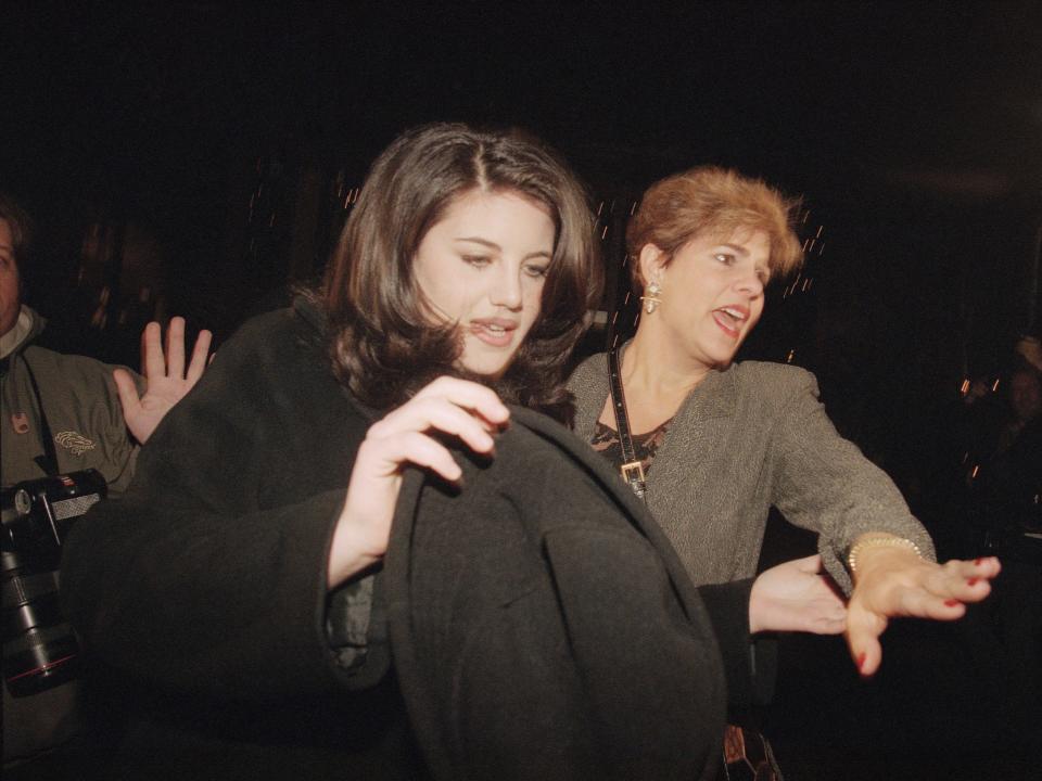 Monica Lewinsky and her stepmother, Barbara Lewinsky, push through a large crowd of media as they leave at a Santa Monica, California, restaurant on February 5, 1998.