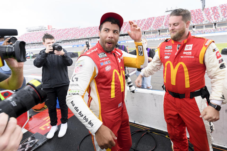 Bubba Wallace, center, celebrates after being pronounced the winner while waiting out a rain delay before which he was the leader in a NASCAR Cup series auto race Monday, Oct. 4, 2021, in Talladega, Ala. (AP Photo/John Amis)