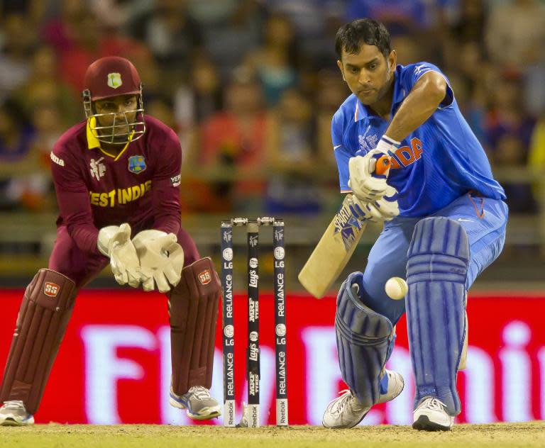 Indian batsman MS Dhoni (right) plays a shot watched by West Indies wicketkeeper Denesh Ramdin during their 2015 Cricket World Cup match in Perth on March 6, 2015