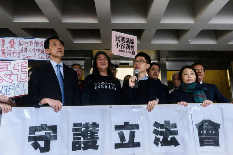 Pro-democracy lawmakers (L-R) Edward Yiu, “Long Hair” Leung Kwok-hung, Nathan Law and Lau Siu-lai hold a banner outside the High Court in Hong Kong