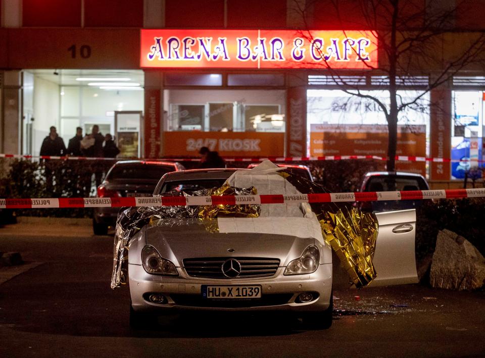 A car with dead bodies stands in front of a bar in Hanua, Germany Thursday, Feb. 20, 2020. German police say several people were shot to death in the city of Hanau on Wednesday evening. 