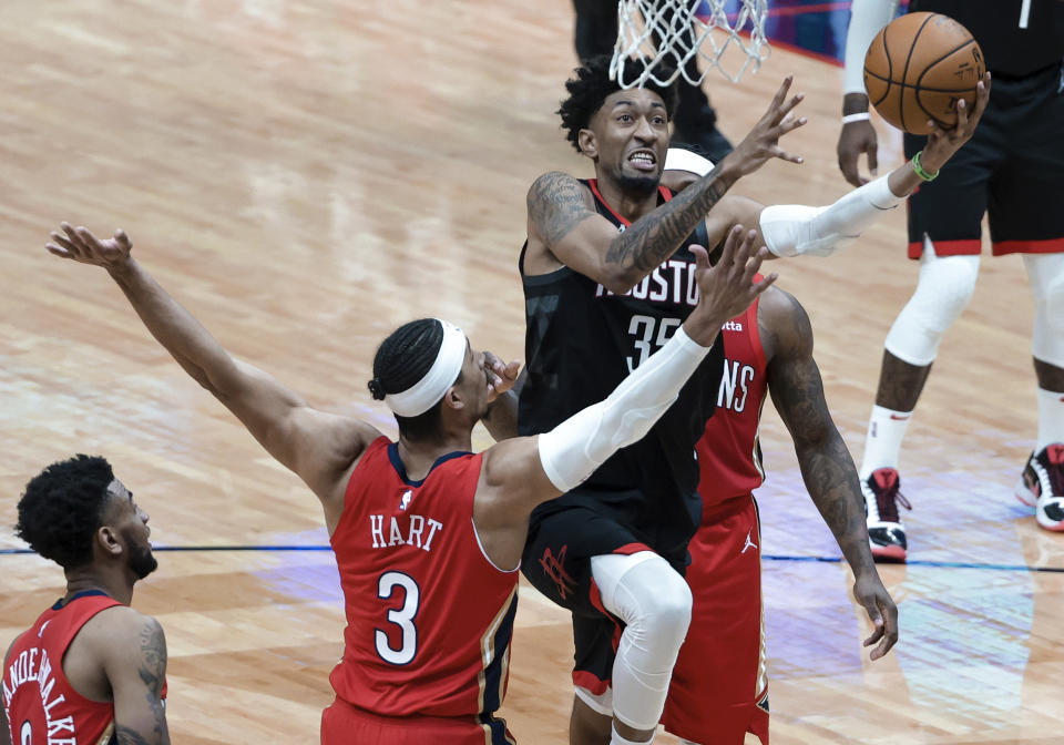 Houston Rockets center Christian Wood (35) shoots past New Orleans Pelicans guard Josh Hart (3) and forward Zion Williamson (1) during the second quarter of an NBA basketball game in New Orleans, Saturday, Jan. 30, 2021. (AP Photo/Derick Hingle)