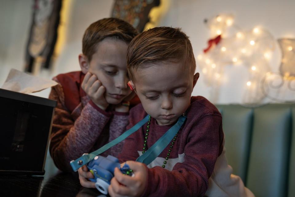 August (rirght) and his older brother Bryant (left) play a game on his toy camera on Dec. 9, 2023.