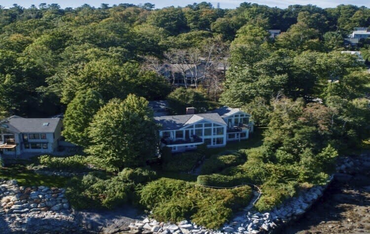 This undated image provided by Vinal Applebee shows the home of Lisa Gorman in the foreground, the poisoned oak trees behind her home, and the home of the perpetrators behind the dead trees, in Camden, Maine. (Vinal Applebee via AP)